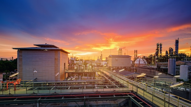 Petrochemische industriefabriek bij zonsondergang, productie van industriële olieraffinaderij