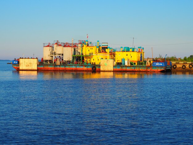 Petrozavodsk Rusland 10 juli 2021 Rivierstation of zeehaven Magazijnen en productiefaciliteiten Pier op Lake Onega Karelia Autobanden worden aan de zijkanten van de pier geplaatst Waterhemel en horizon