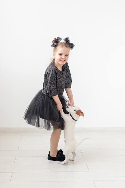 Animali domestici e concetto di animali - ragazza del bambino che gioca con il cucciolo jack russell terrier.