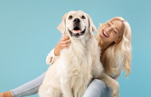 Pets and people concept happy young lady posing with her adorable golden retriever dog sitting over