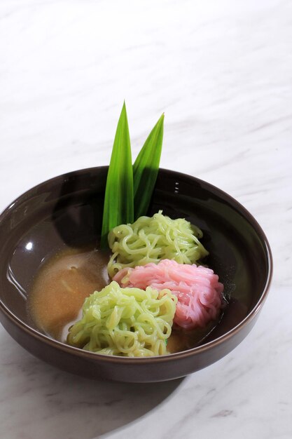 Petulo of Putu Mayang is een traditionele Indonesische snack gemaakt van strengen rijstmeel, geserveerd met kokosmelk en palmsuikersaus