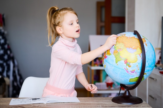 Peuter meisje dat aardebol thuis bekijkt