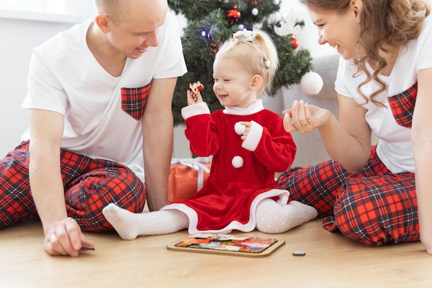 Peuter met cochleair implantaat speelt met ouders onder kerstboomdoofheid en innoverende medische technologieën voor hoortoestellen en diversiteit