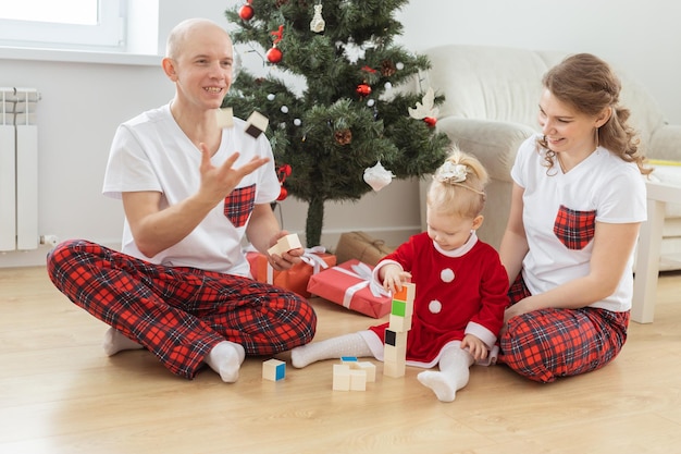 Peuter met cochleair implantaat speelt met ouders onder kerstboomdoofheid en innoverende medische technologieën voor hoortoestellen en diversiteit