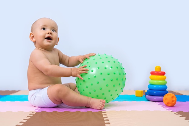 Peuter speelt met een grote rubberen massagebal