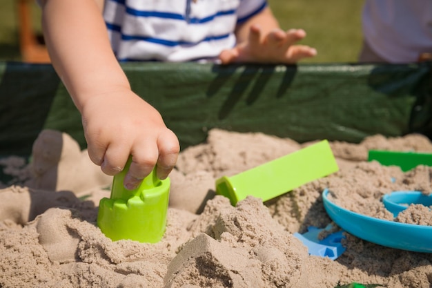 Peuterhanden die buiten met kinetisch zand spelen Kind maakt vormen Lifestyle en zomerconcept