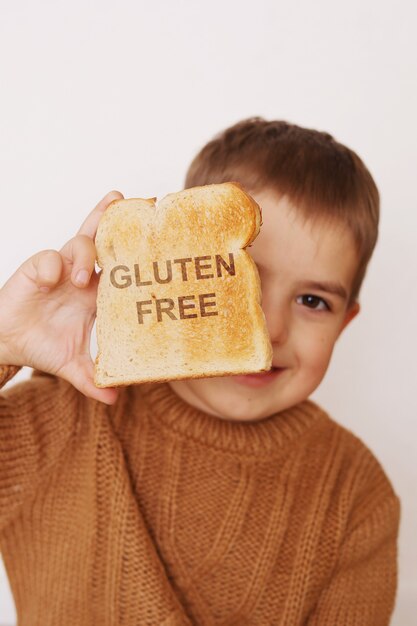 Peuterjongen met geroosterd brood zonder gluten. Gezond eten. Glutenintolerantie bij kinderen.