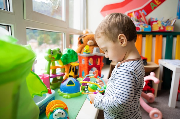 Peuterjongen speelt met educatief speelgoed in de kinderkamer De studie van kleuren en de ontwikkeling van tactiliteit Kind anderhalf jaar twee jaar Selectieve aandacht