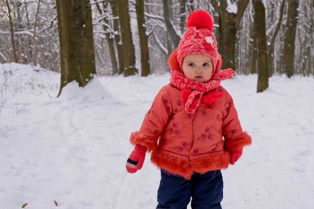 Peutermeisje dat door sneeuw in het park loopt. frost winterseizoen.