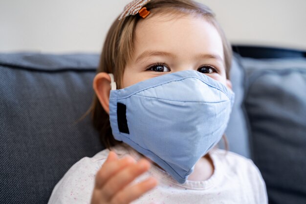 Peutermeisje met medisch masker op het gezicht. Coronavirus-uitbraak