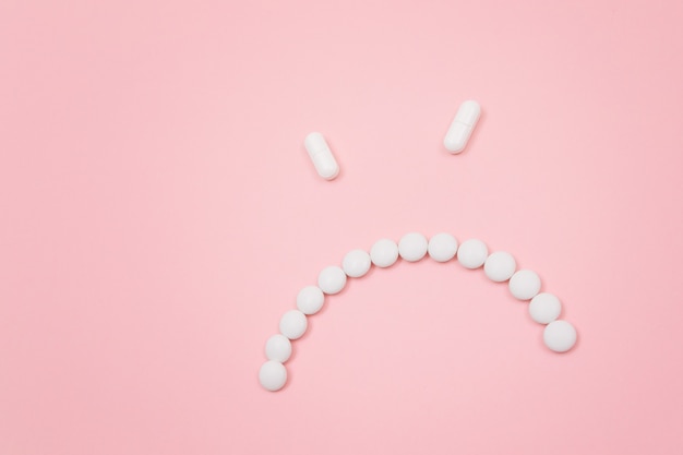 Pharma harm angry smiley face made from white pills