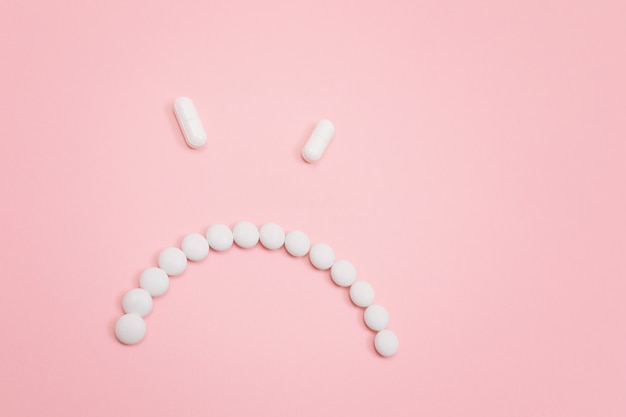 Pharma schaadt boos smileygezicht gemaakt van witte pillen