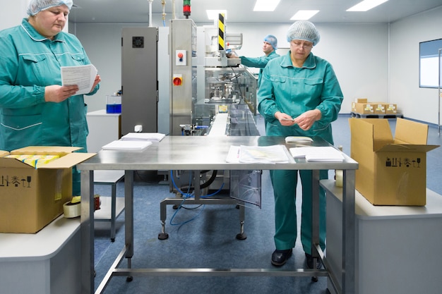 Работники фармацевтического завода в стерильной среде