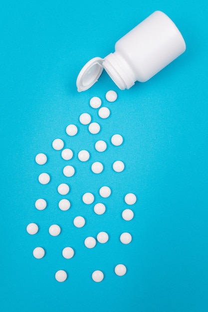 Pharmaceutical industry and medicinal products  white pills on blue background