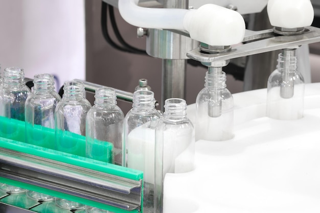 Pharmaceutical industry medicine pills are filling in the plastic bottle on production line machine conveyor at the medical factory selective focus