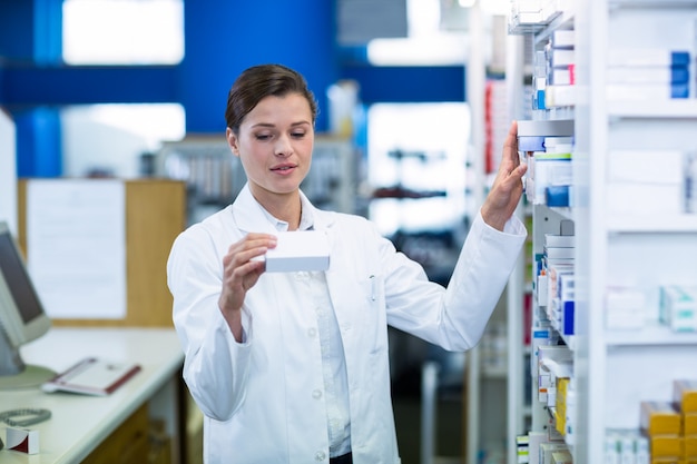 Foto farmacista che controlla medicina in scaffale