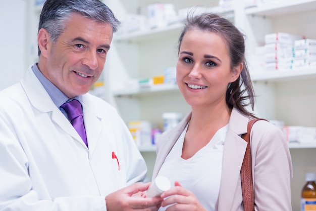 Pharmacist and customer looking at camera