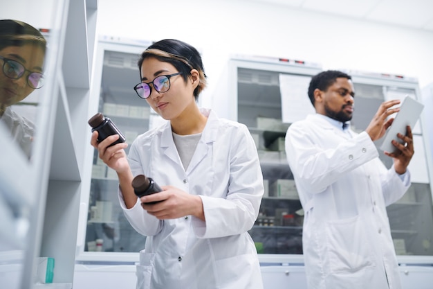 Pharmacist finding necessary pills in storage room