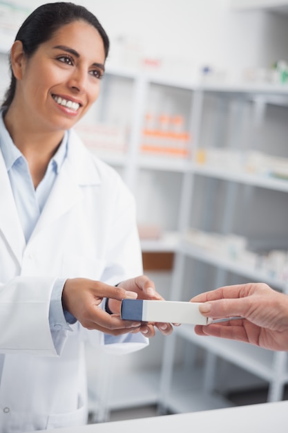 Pharmacist giving a drug box to someone