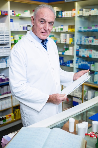 Pharmacist holding a clipboard in pharmacy