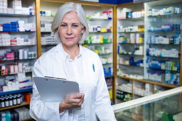 Pharmacist holding a clipboard in pharmacy