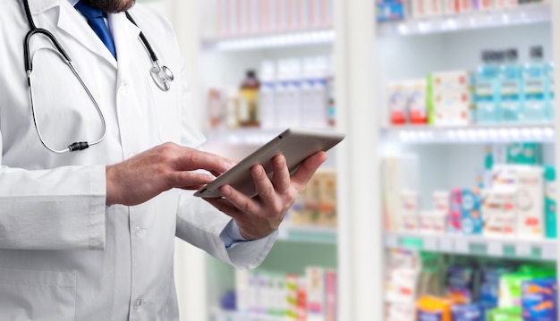 Pharmacist holding computer tablet Using for filling prescription in pharmacy drugstore.