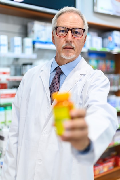 Farmacista che tiene un barattolo di pillole