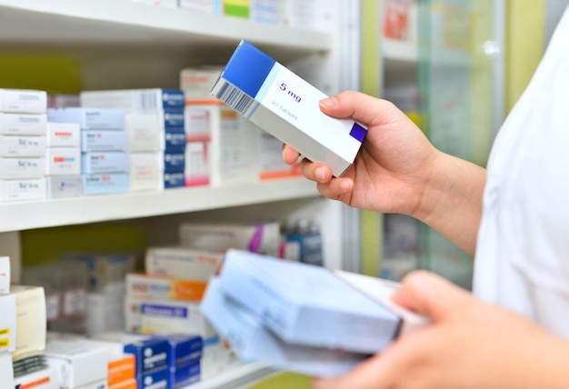 Pharmacist holding medicine box in pharmacydrugstore