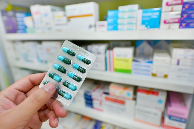 Pharmacist holding medicine capsule pack at the pharmacy drugstore