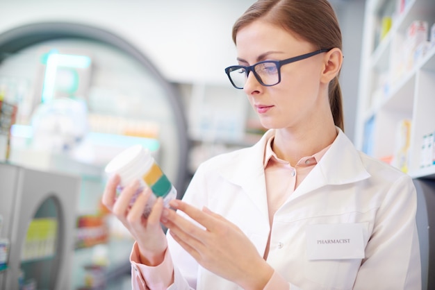 Foto il farmacista rivede l'etichetta del medicinale sulla bottiglia