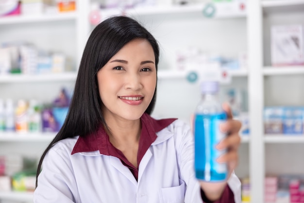 Pharmacist show bottle hand gel in drugstore