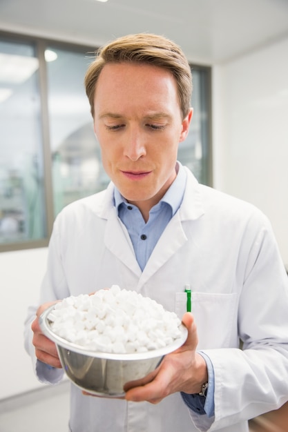 Pharmacist showing bowl of pills