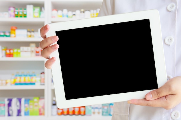 Pharmacist showing tablet computer in the pharmacy store