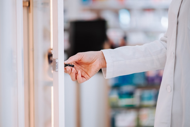 Pharmacist taking medication from a shelf, close-up.