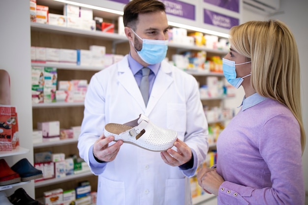 Pharmacist talking to the customer and recommending which shoes to buy.