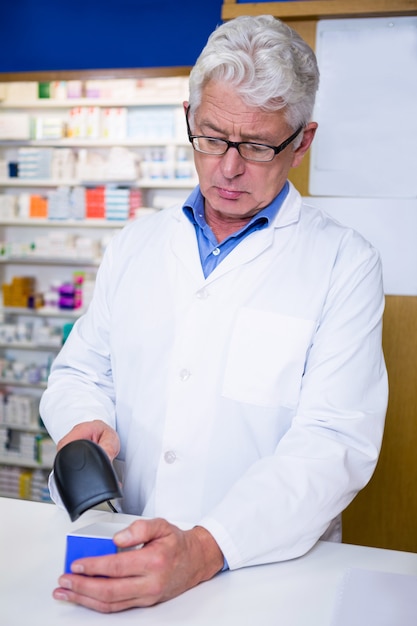 Pharmacist using barcode scanner on medicine box