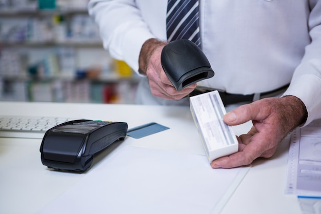 Pharmacist using barcode scanner on medicine box