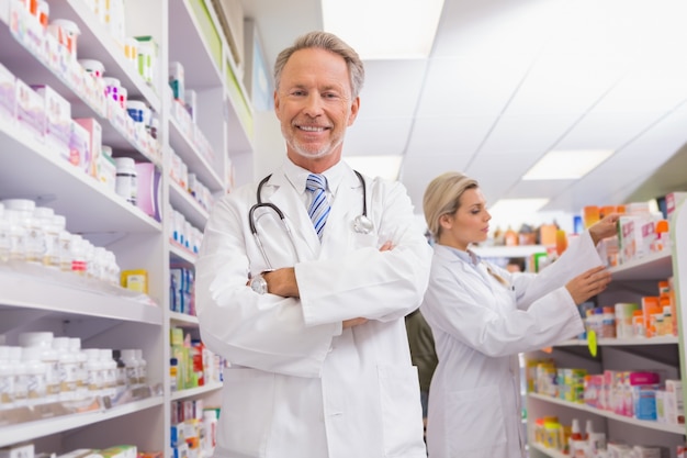 Pharmacist with arms crossed and trainee behind