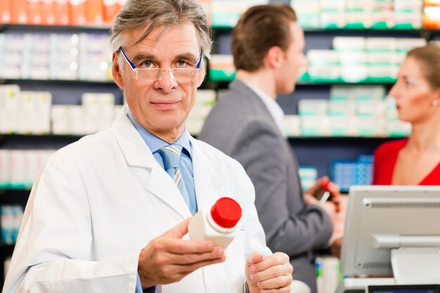 Pharmacist with customers in pharmacy