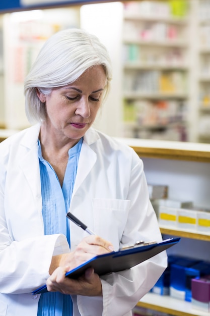 Pharmacist writing on clipboard