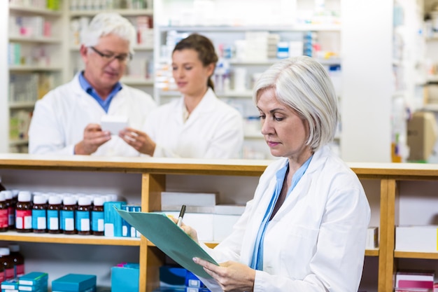 Pharmacist writing on clipboard