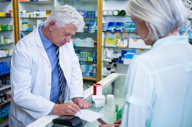 Foto farmacista che scrive prescrizioni per medicinali