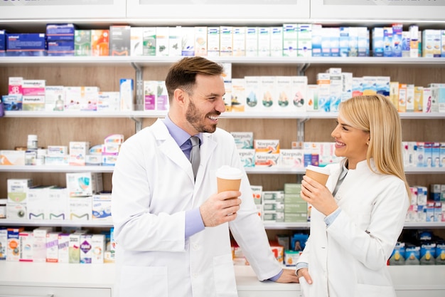 Pharmacists drinking coffee in drug store and having conversation.