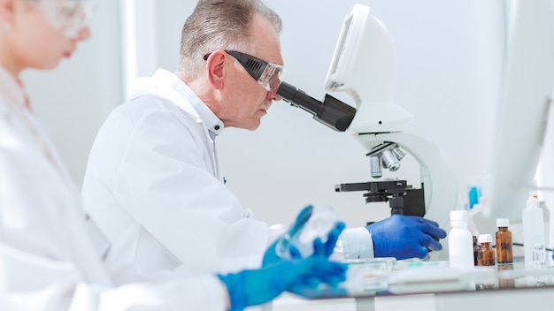 pharmacists from all over using microscope in the laboratory.