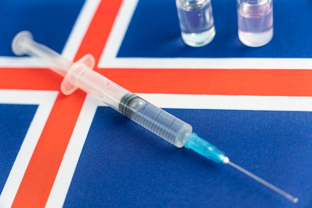 Pharmacology and Medicine iceland concept vaccine against coronavirus covid national pharmacological industry Vaccine ampoules syringe against the background of national flag