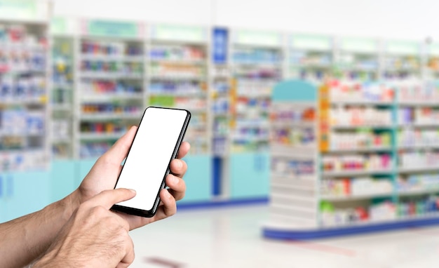 Pharmacy background blur counters of pharmacy with medicines tablets pills and hand with smartphone