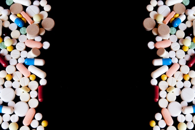 Pharmacy background on a dark table. Levitation pills. Tablets on a dark background which falling down. Pills. Medicine and healthy. Close up of capsules. Pills falling on black background