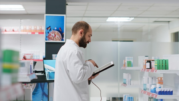 Pharmacy clerk inspects supply of pharmaceuticals on aisles