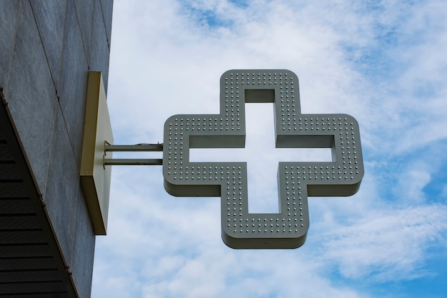 Photo pharmacy cross in the background against the sky with clouds.