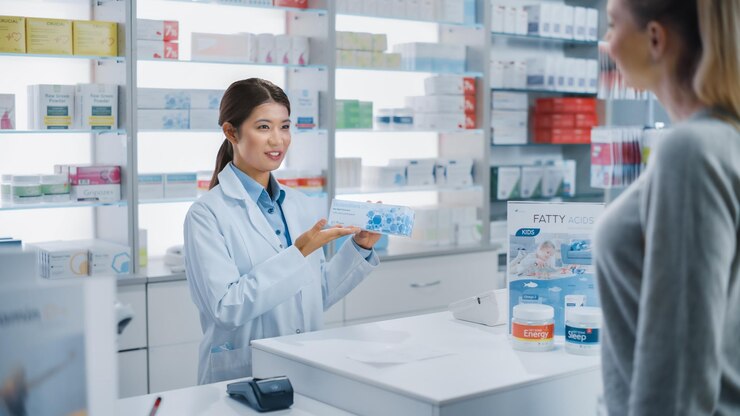 薬局のチェックアウト キャッシャー カウンター プロのアジア人女性薬剤師が 美しい白人女性顧客に 包装された薬をめています